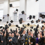 UVA Darden MBA graduates throwing hats into the air