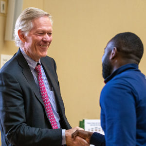 Dean Beardsley shakes hand of Taiwo Abiodun Darden Global Leadership Scholarship