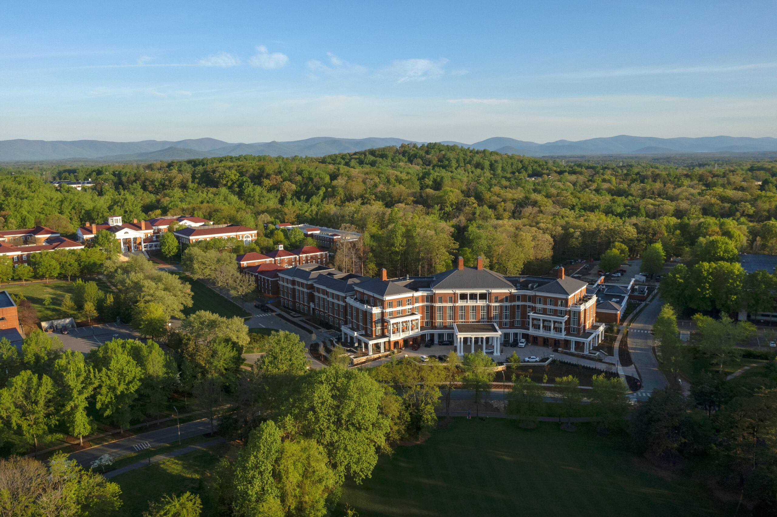 Aerial photo of UVA Darden North Grounds, including The Forum Hotel and Blue Ridge mountain views.