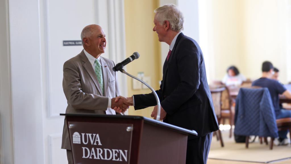 Frank Genovese and Dean Scott Beardsley shake hands at the podium following the 2025 fellowship announcement at UVA Darden.